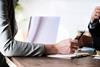 Photo of arm across a desk to signify a meeting, giving advice