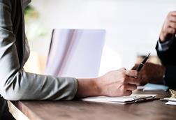 Photo of arm across a desk to signify a meeting, giving advice