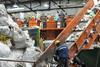 Workers on a conveyor belt in a recycling plant